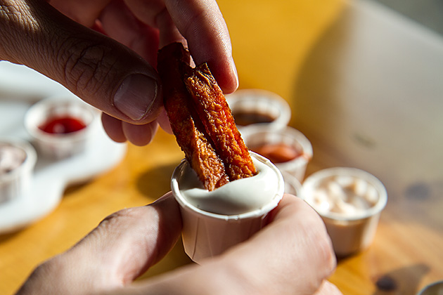 Dipping fries into french fries sauce