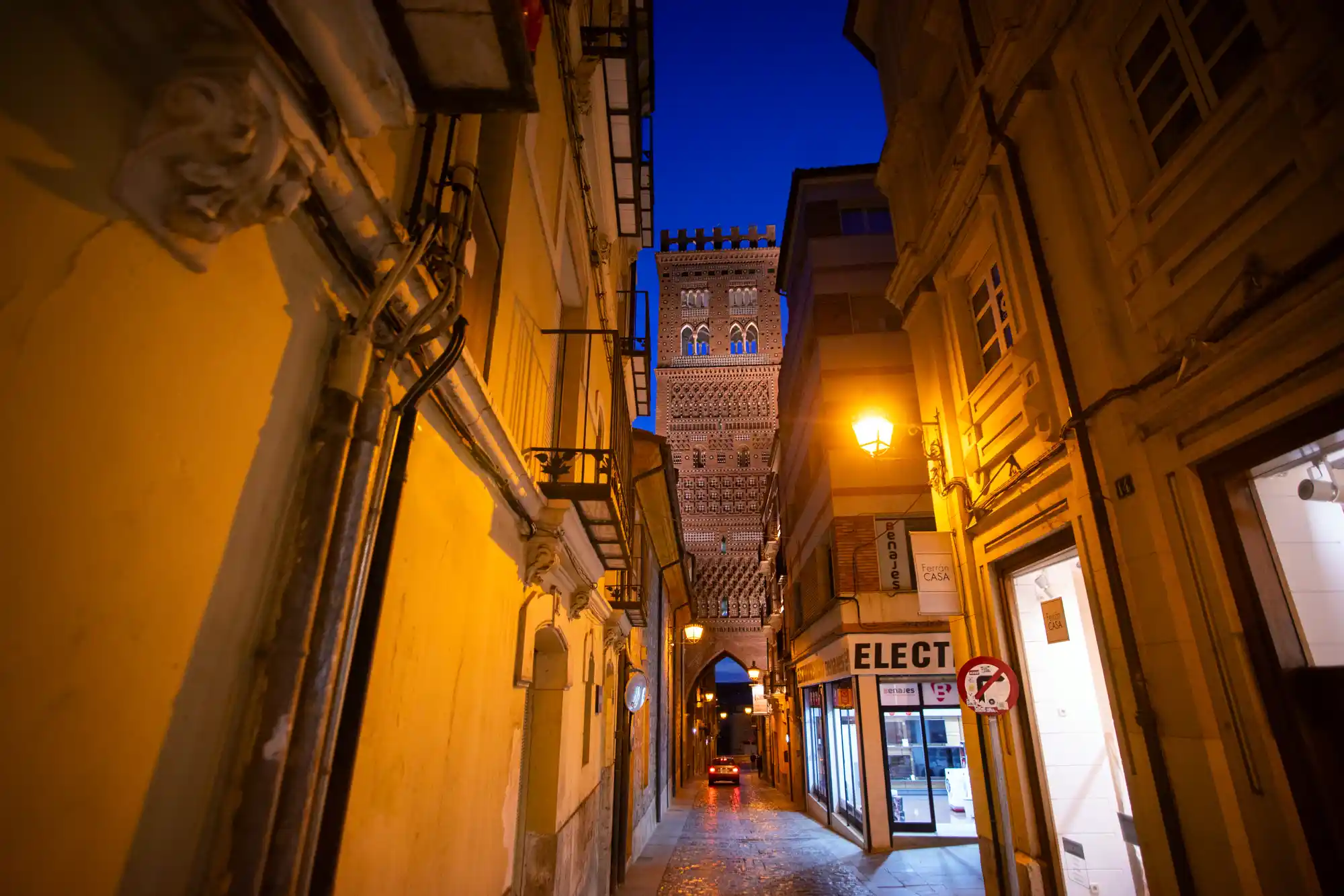 Teruel narrow street and an old tower at night.