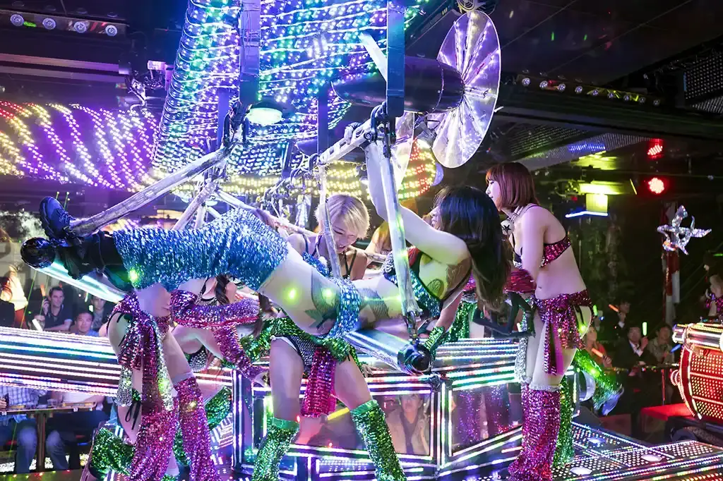 Dancers in glittering costumes perform on a giant robotic stage at Tokyo's Robot Restaurant